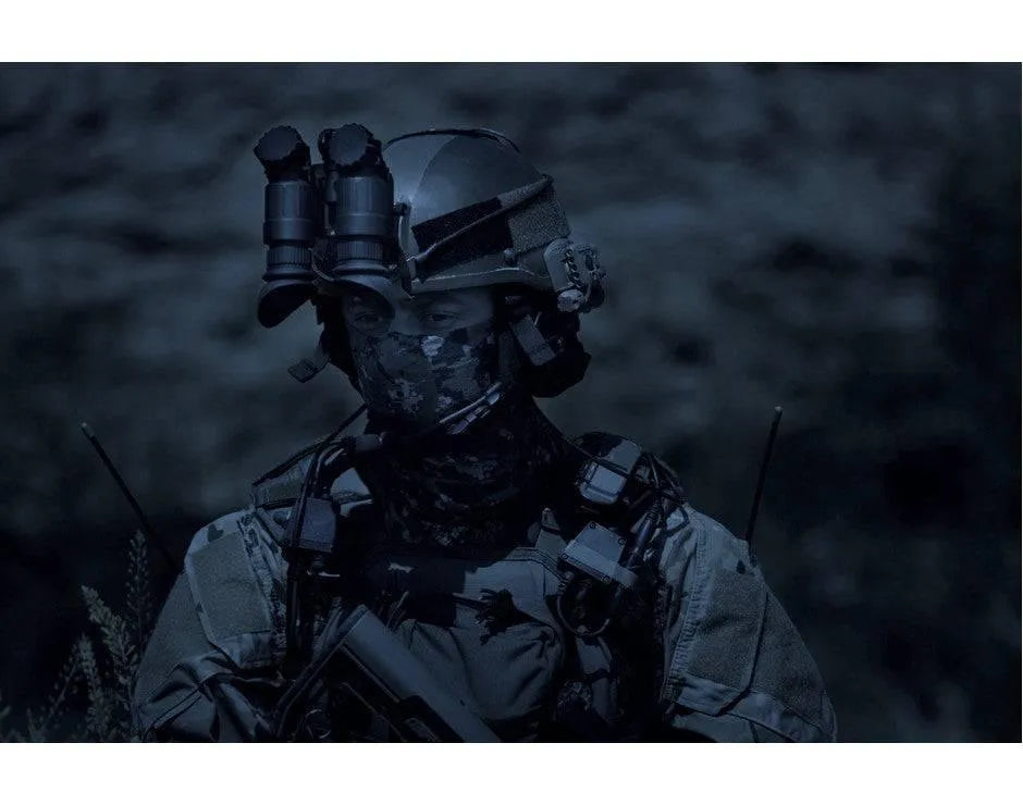 Tactical operator wearing helmet with AGM NVG-40 Gen 3 night vision binoculars at night