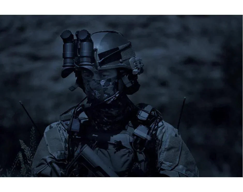 Tactical gear operator wearing helmet-mounted Gen 3 night vision binoculars at night