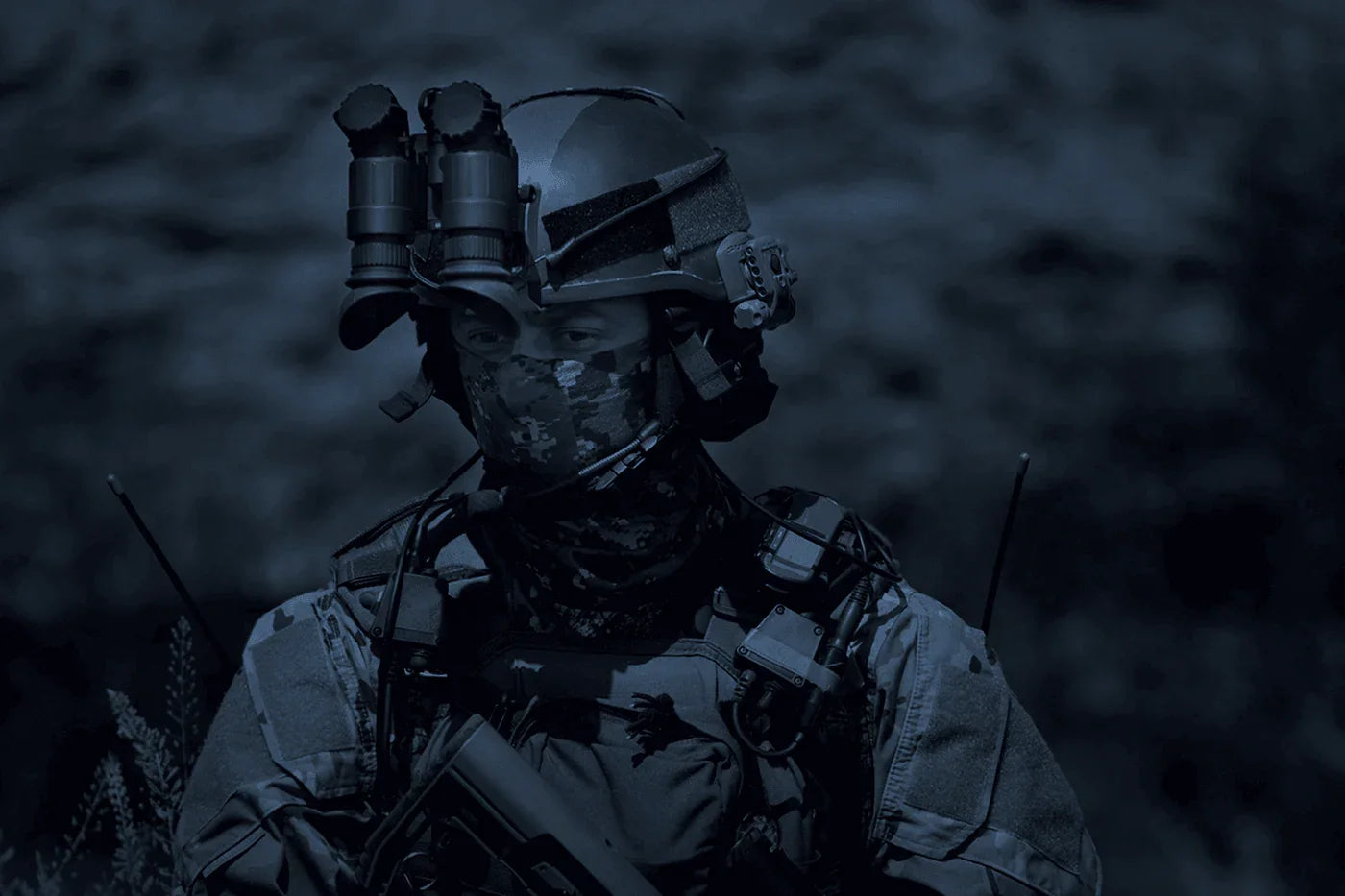 Soldier wearing AGM NVG-40 night vision binoculars Gen 3 on helmet at night