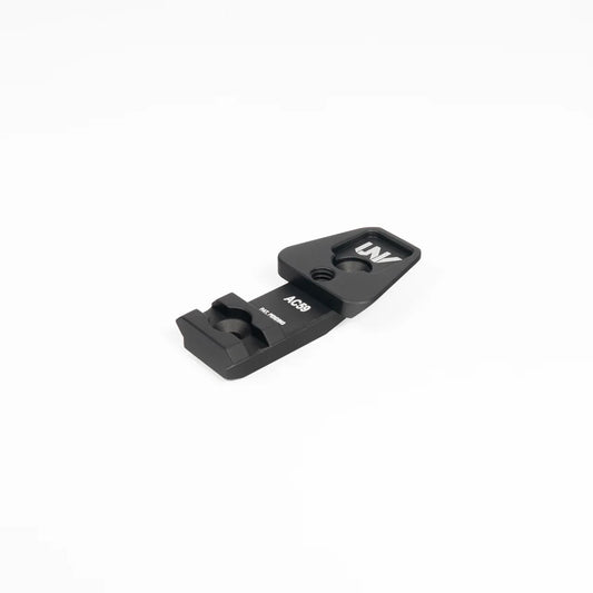 Black metal optic mount accessory marked AC39 and UNV, isolated on white background